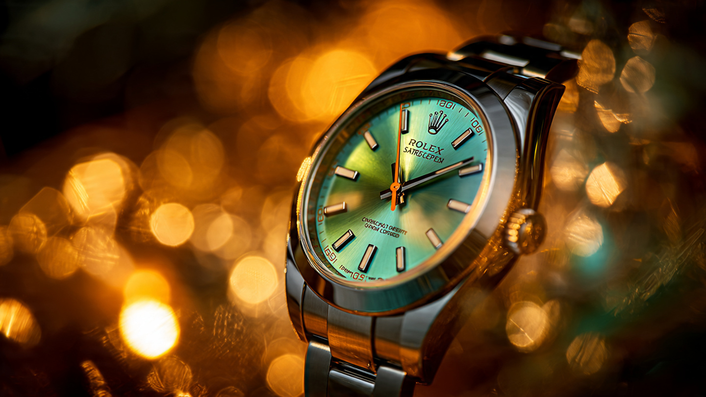 Close-up of green-tinted sapphire watch crystal refracting warm amber light