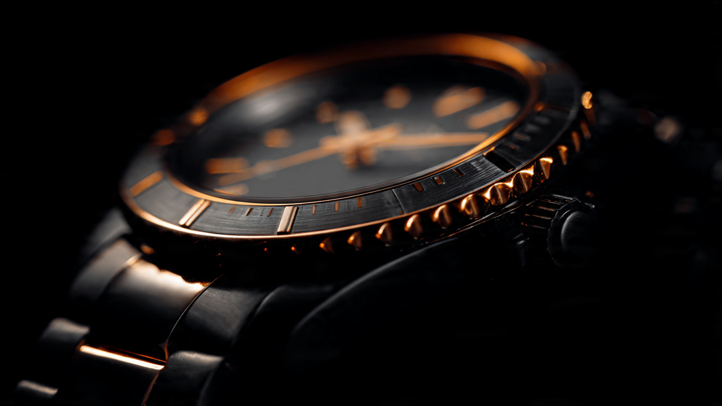 Macro photograph of a black ceramic watch case with integrated bracelet links under warm amber directional lighting, showing polished beveled edges transitioning to satin-brushed flat surfaces on the zirconium oxide ceramic
