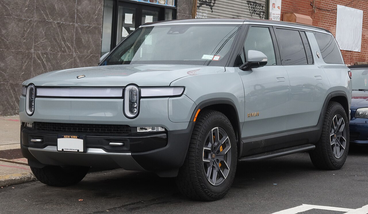Rivian R1S in motion, dark exterior, conveying dynamic driving